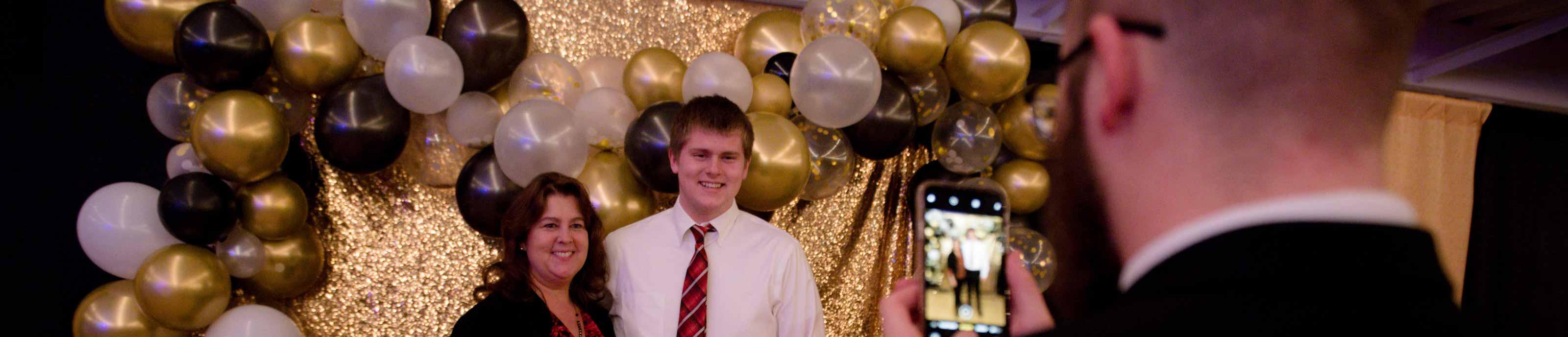 A mother and son pose for a photo at the Mother-Son Father-Daughter Banquet & Dance