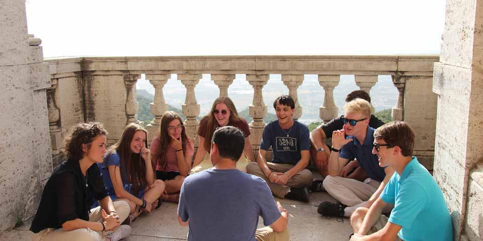 A group of students talking in a circle in Italy.